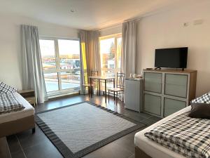 a room with a bed and a television and a table at Gemütliches Doppelzimmer Gemeinschaftsbad in Dingolfing