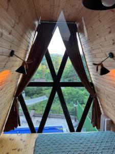a bedroom with a large window in a wooden house at Barbare Cottage in Chakvi +28 photos