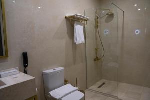 a bathroom with a shower and a toilet and a sink at Crixus Hotels Sarsing in Sarsing +36 photos