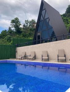a group of chairs sitting next to a swimming pool at Barbare Cottage in Chakvi