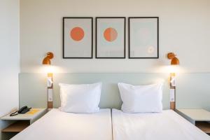 a bedroom with a white bed with three pictures on the wall at SOL by Meliá Nessebar Mare All Inclusive in Nesebar