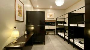 a room with two bunk beds and a desk with a lamp at Lavung Village in Ða Gia