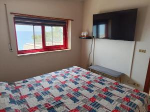 a bedroom with a bed with a quilt and a window at Stella Marina in Bova Marina