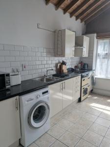 a kitchen with a washing machine and a sink at The Stables in Aglish