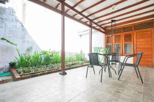 a patio with a table and chairs on a patio at Omah Alamanda in Sleman