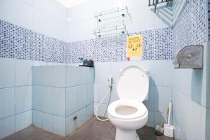 a bathroom with a toilet in a blue tiled room at Omah Alamanda in Sleman +30 photos