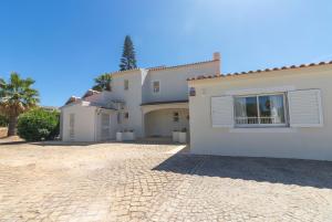 a large white house with a brick driveway at Villa Ursa by Algarve Holidays in Praia do Carvoeiro