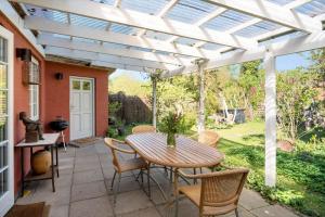 a patio with a table and chairs under a white pergola at 4263-Stege-Mollebrondstraede-13 in Stege