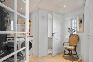 a laundry room with a washing machine and a chair at 4263-Stege-Mollebrondstraede-13 in Stege