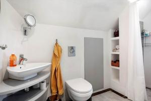 a white bathroom with a toilet and a sink at 4263-Stege-Mollebrondstraede-13 in Stege +9 photos