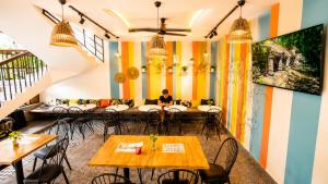 a restaurant with colorful walls and tables and chairs at LOTUS SERENITY Hostel in Siem Reap