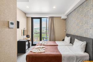 a hotel room with two beds and a large window at Brooch Boutique Hotel in Tbilisi City