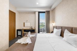 a hotel room with a large bed and a balcony at Brooch Boutique Hotel in Tbilisi City