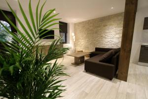 a living room with a couch and a plant at Le Moulin d'Oscar & Spa - Mulhouse Nord in Baldersheim