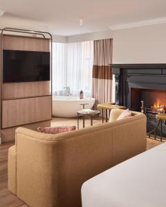 a living room with a couch and a fireplace at The Met Hotel Leeds - Newly Refurbished in Leeds