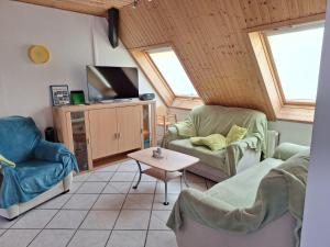 a living room with two chairs and a tv at Hof Junkernberg in Bispingen