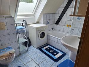 a bathroom with a washing machine and a sink at Hof Junkernberg in Bispingen