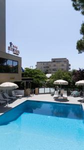 a large blue swimming pool with chairs and umbrellas at Hotel Simon in Gatteo a Mare
