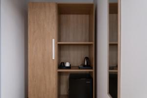 a wooden cupboard with a coffee maker in it at Torre 47 - 49 Rooms in Lamezia Terme
