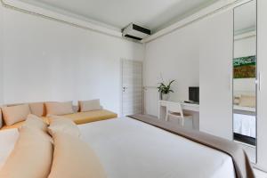 a white bedroom with a bed and a couch at Hotel Simon in Gatteo a Mare