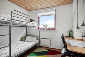 a bedroom with a bunk bed and a desk and a window at 1039-Stege-Rylevej-30 in Stege