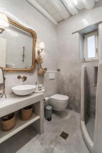 a bathroom with a sink and a toilet and a mirror at Nest Gateway - Panoramic Mountain Views in Apoíkia +16 photos