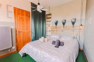 a bedroom with a bed with towels and a fan at La Tour de La Palme in Lapalme +25 photos