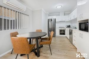 a kitchen with a table and chairs in a room at KozyGuru | Penrith | Spacious Ground Floor Gem in Penrith