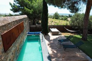 a swimming pool in a stone wall with two chairs at La Tour de La Palme in Lapalme