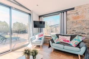 a living room with a couch and a tv and windows at La Tour de La Palme in Lapalme