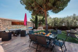 a patio with tables and chairs and a tree at La Tour de La Palme in Lapalme