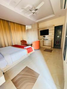 a bedroom with a bed and a flat screen tv at Hotel SS Grand in Lucknow
