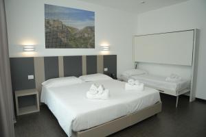 a bedroom with two beds with towels on them at HOTEL MOSAICO in Matera +65 photos