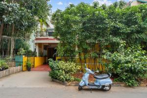 a scooter parked in front of a house at Vintage Haven Leafy Getaway Luxury Villa in Indiranagar by Spacez in Bangalore