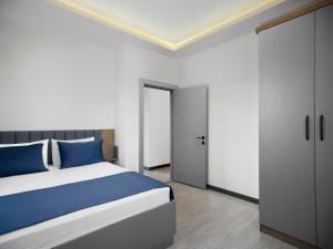 a bedroom with a large bed with blue pillows at Silence Garden Suite bir yatak odalı daire in Alanya +26 photos