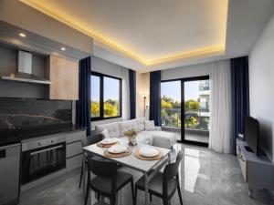 a kitchen and living room with a table and chairs at Silence Garden Suite bir yatak odalı daire in Alanya