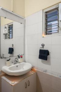a white bathroom with a sink and a mirror at Vintage Haven Leafy Getaway Luxury Villa in Indiranagar by Spacez in Bangalore