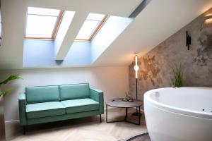 a bathroom with a green couch and a bath tub at Bohemia Jacuzzi & Sauna Apartment in Klaipėda