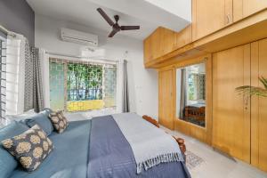 a bedroom with a blue bed and a window at Vintage Haven Leafy Getaway Luxury Villa in Indiranagar by Spacez in Bangalore +33 photos