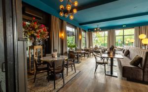 a restaurant with tables and chairs and a couch at De Zwaan Delden in Delden