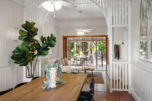 a living room with a wooden table and a dining room at Pacific Terrace Beach House in Coolum Beach