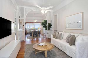 a living room with a white couch and a table at Pacific Terrace Beach House in Coolum Beach