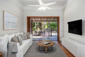 a living room with a white couch and a table at Pacific Terrace Beach House in Coolum Beach