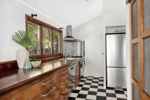 a kitchen with a black and white checkered floor at Pacific Terrace Beach House in Coolum Beach +17 photos