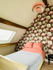 a bedroom with a bed with flowers on the wall at Au Petit Paradis in Saint-Domet