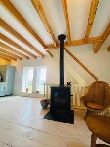 a living room with a wood stove in a room at Au Petit Paradis in Saint-Domet
