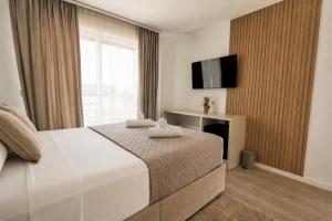 a bedroom with a large white bed with a television at Magnolia in Alicante