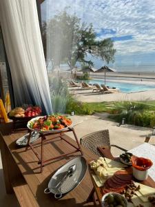a table with a tray of food and a view of the beach at Riva Hua Hin in Ban Khao Takiap