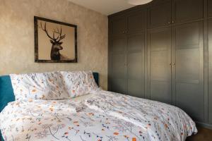 a bedroom with a bed and a painting of a deer at KAJKl 15 in Lidzbark Warmiński +48 photos