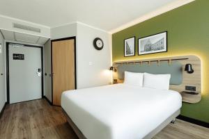 a large white bed in a room with a green wall at Campanile PRIME - Lublin in Lublin